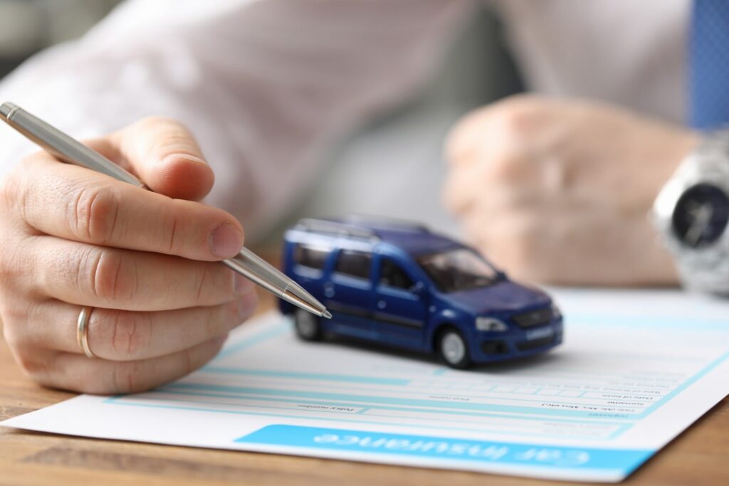 man signing an auto insurance