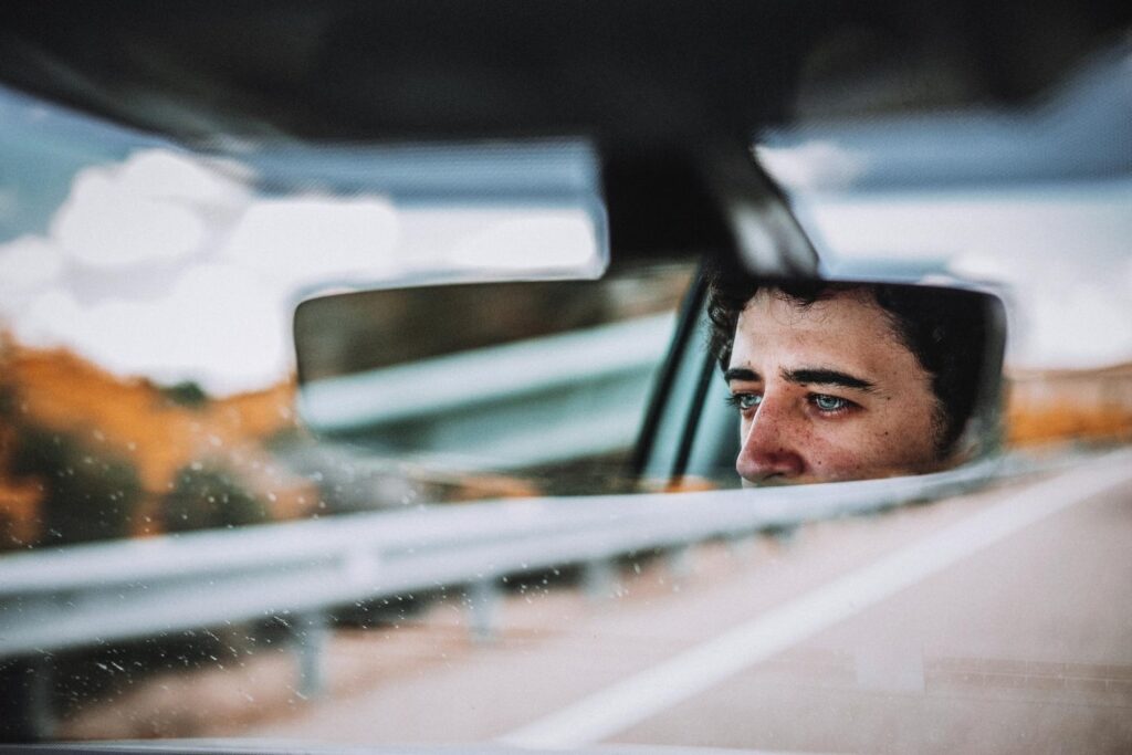 man reflecting in a car mirror